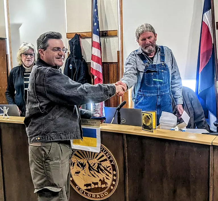 Photo of Saguache County Commissioner, Tom McCracken, presenting David Frees with the "Emergency Manager of the Year" award.